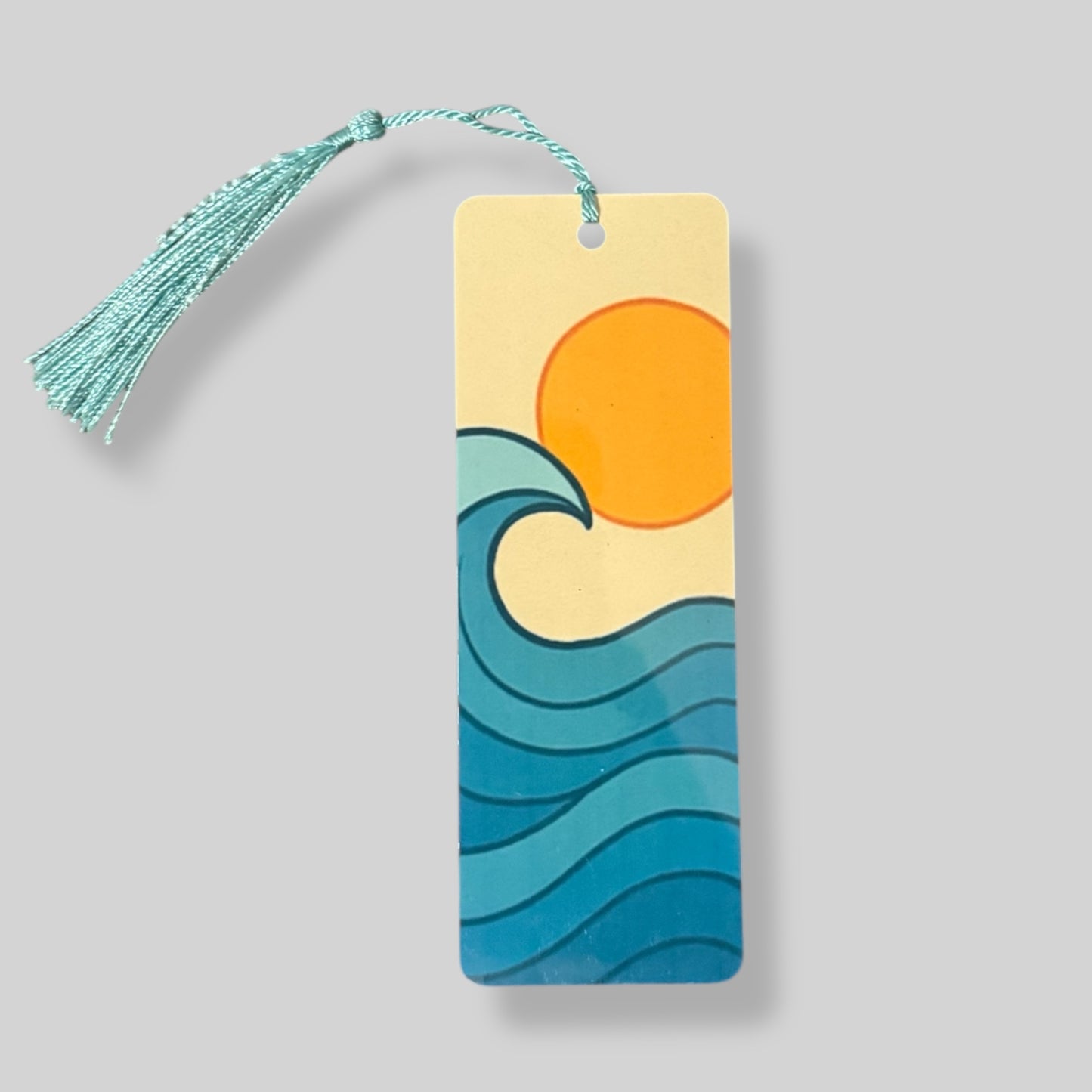 Illustrated orange sun setting over blue waves, ideal for a coastal summer-themed bookmark.