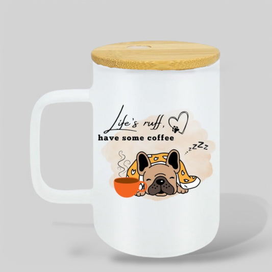 Frosted glass mug with an illustration of a sleepy French bulldog wrapped in a blanket, sipping coffee with the phrase 'Life’s Ruff, Have Some Coffee' in elegant script.