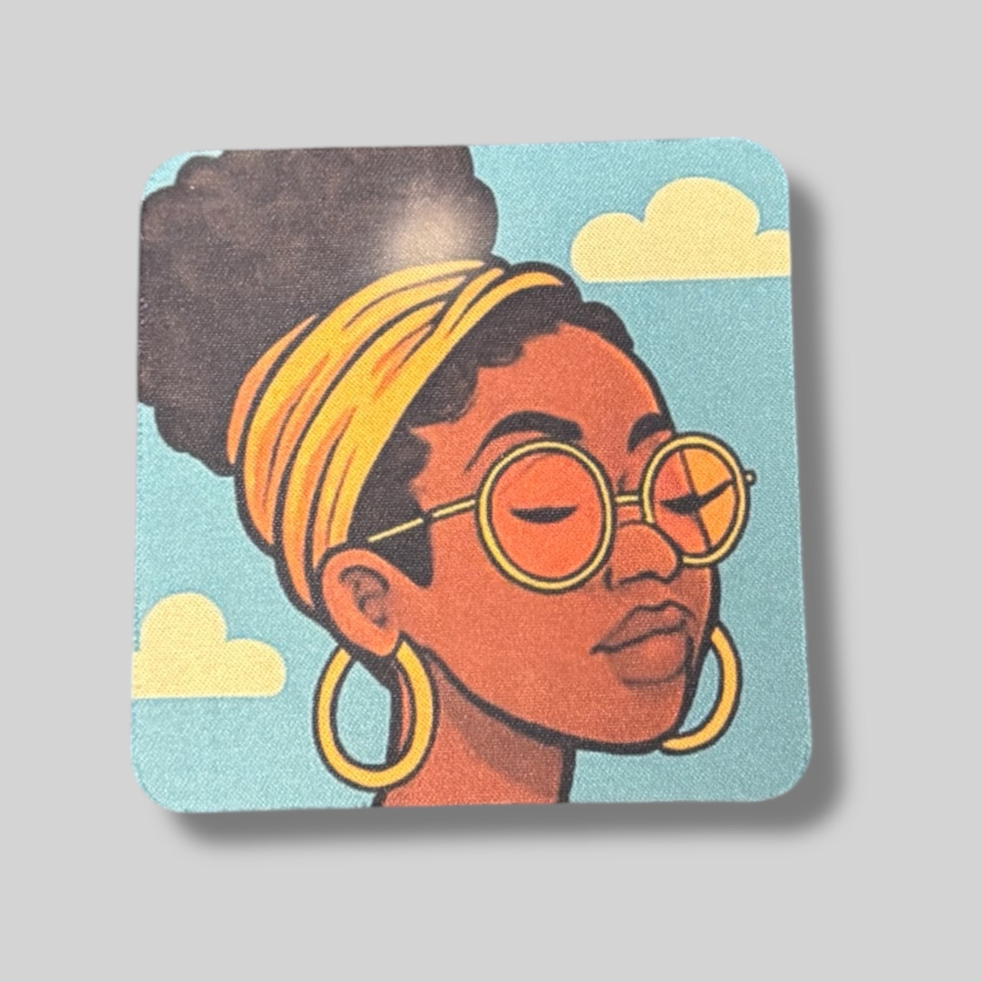 Coaster with woman wearing glasses and a yellow headband, clouds in the background.