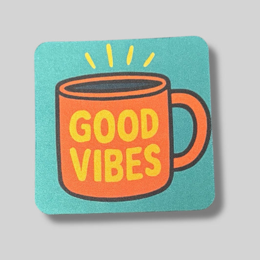 Colorful coaster with an orange coffee mug and the words “Good Vibes” on a teal background.